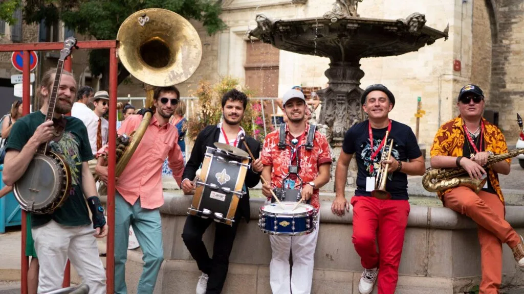 Jazz-band de 6 musiciens avec leurs instruments posant en pleine ville avant un événement d'entreprise