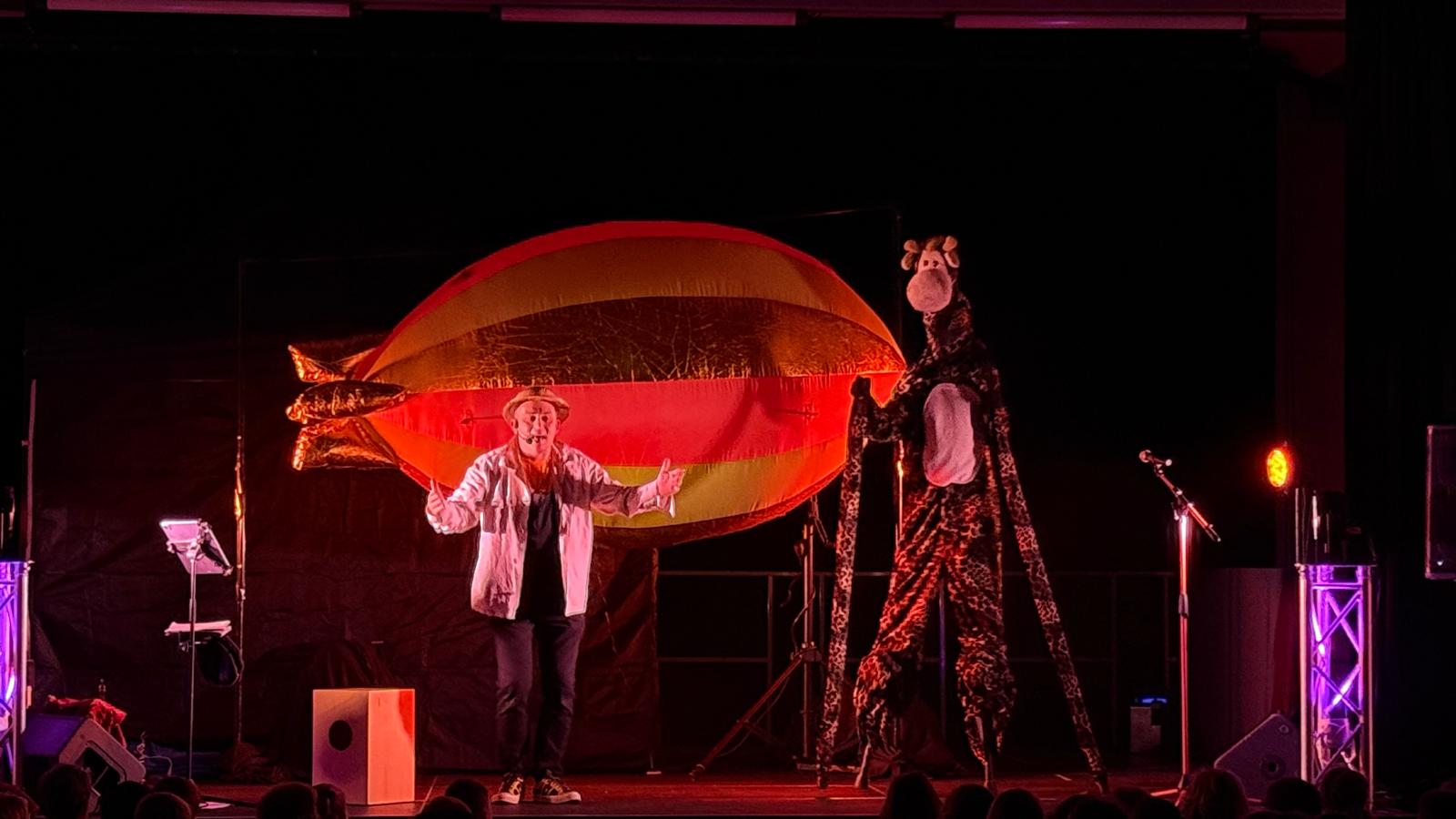 Jay-Jay, son ballon dirigeable et une girafe lors du spectacle L'Envol de Perroquet